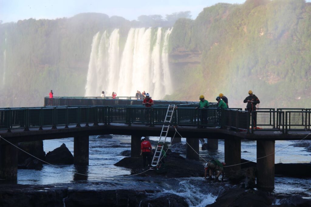 Bombeiros e voluntários retirando moedas do rio Iguaçu